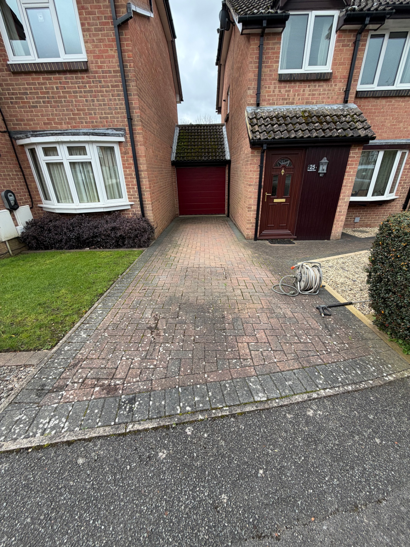 Red and black block paving driveway before cleaning