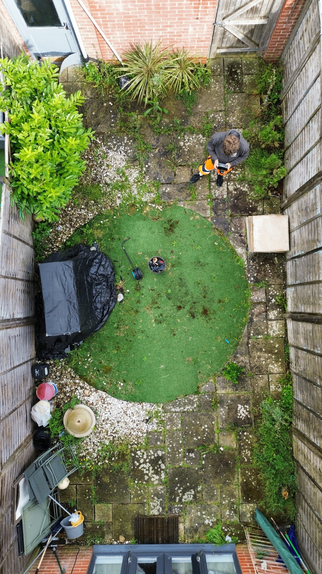 Aerial small courtyard patio with circular lawn before cleaning