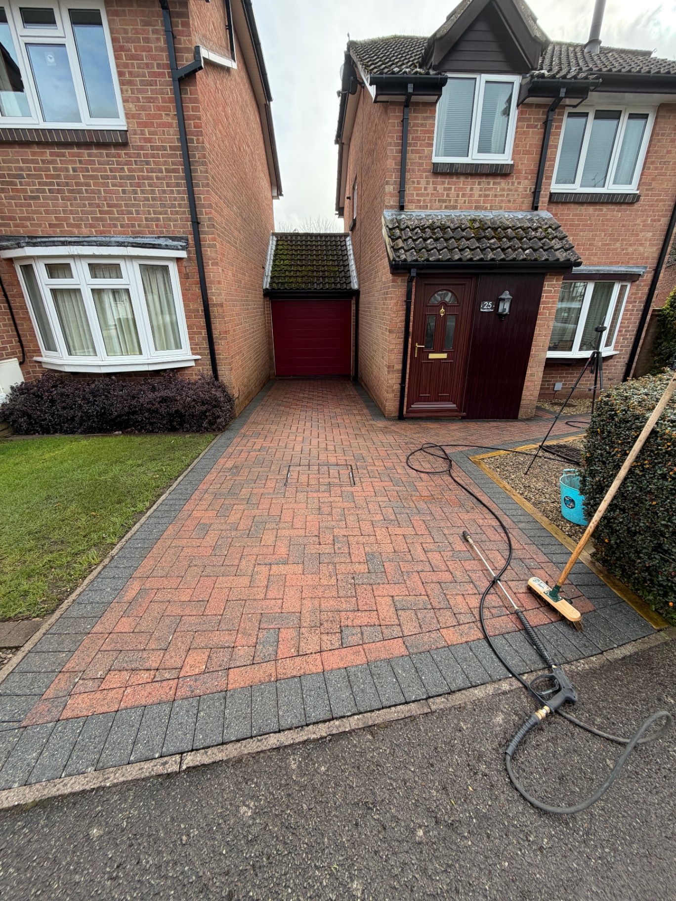 Red and black block paving driveway after cleaning