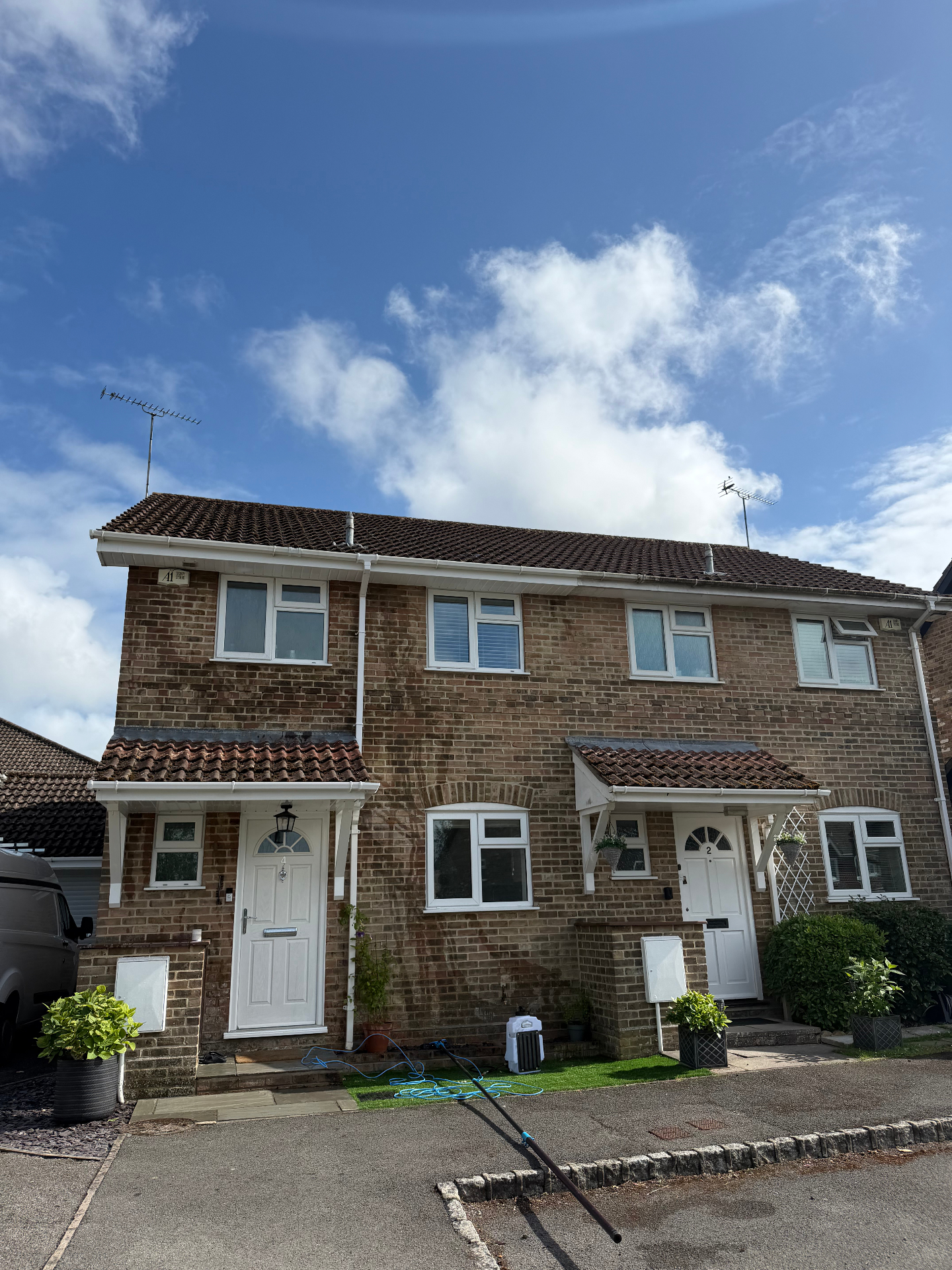 Restored white fascia, soffit and guttering on a brick UK home